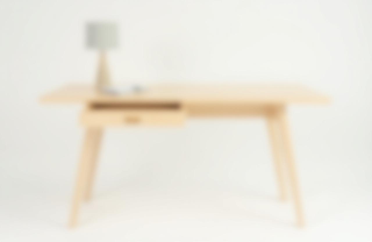 Escritorio minimalista de madera de fresno clara con un cajón integrado, ideal para un espacio de trabajo ordenado y luminoso.